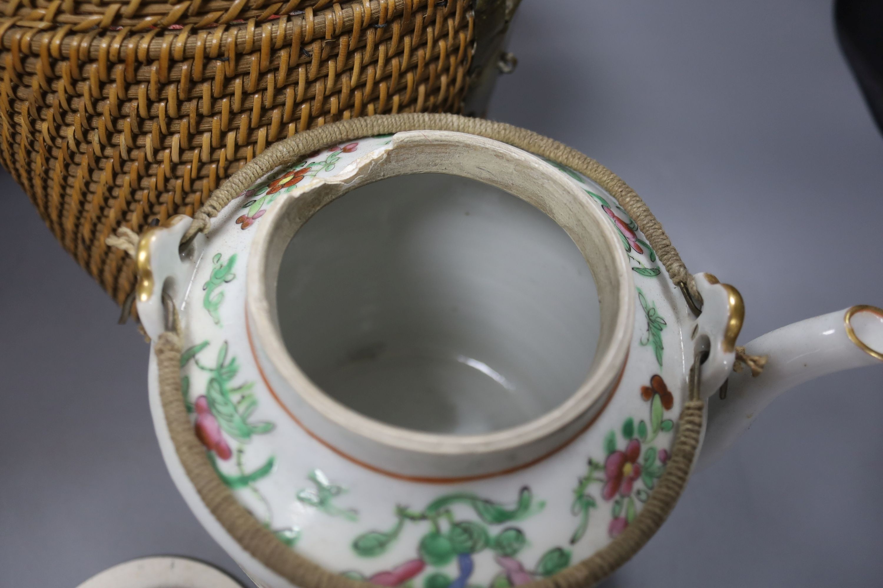 Three late 19th/early 20th century Chinese famille teapots, two in baskets and a similar dish, dish 29.5 cms diameter.